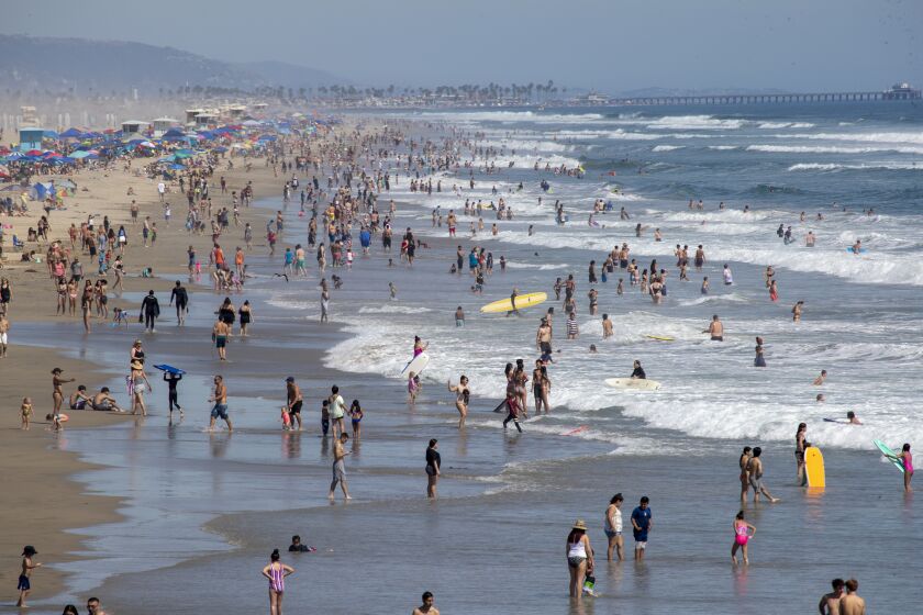 HUNTINGTON BEACH, CA - JUNE 10: Beach goers take to the water to cool off amid high temperatures Wednesday, June 10, 2020 in Huntington Beach, CA. A heat advisory will be in effect today from 11 in the morning until 7 tonight throughout Southern California. (Allen J. Schaben / Los Angeles Times)