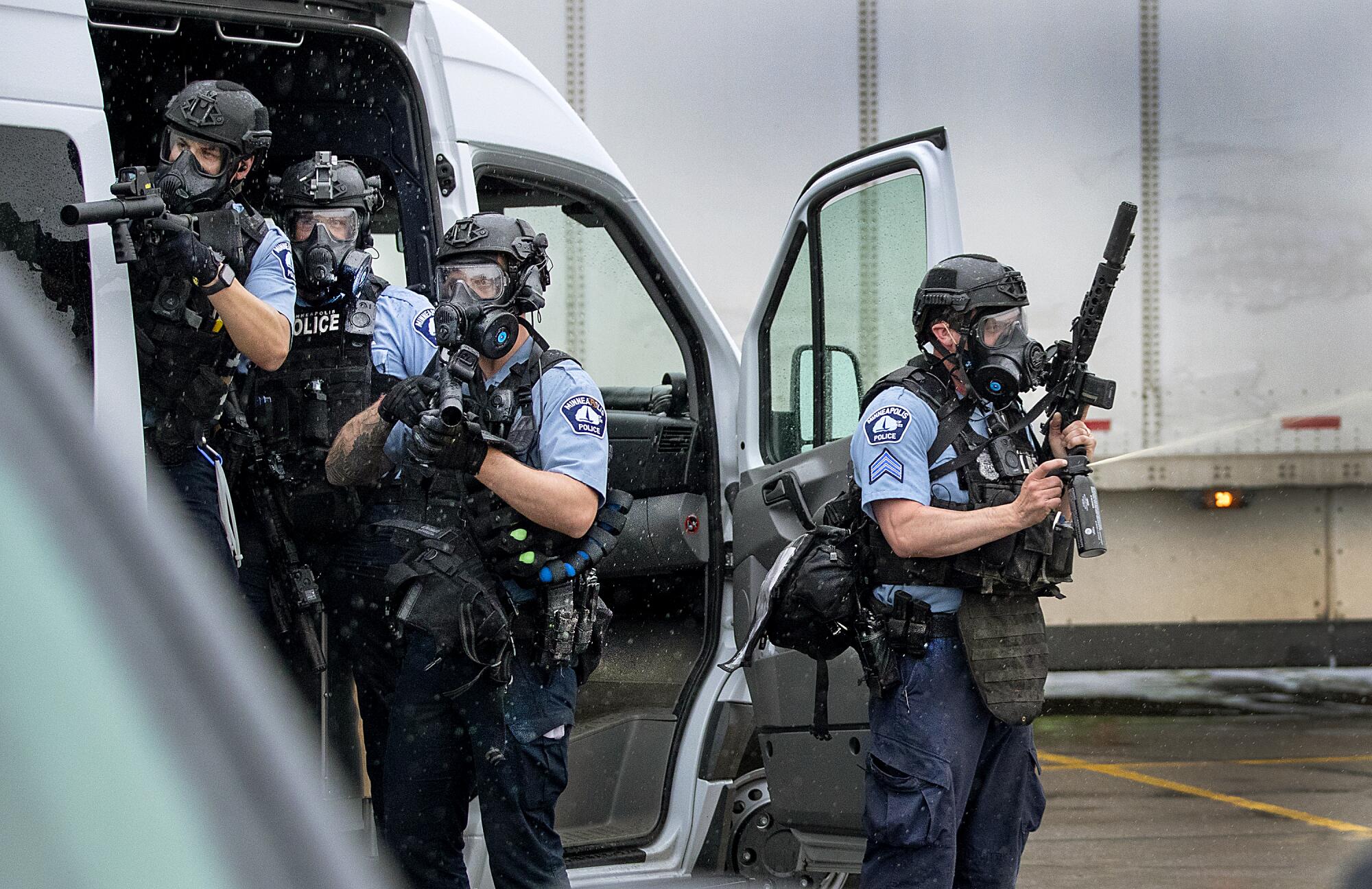 Police officers deploy to disperse protesters in the Target parking lot near a Minneapolis police station.