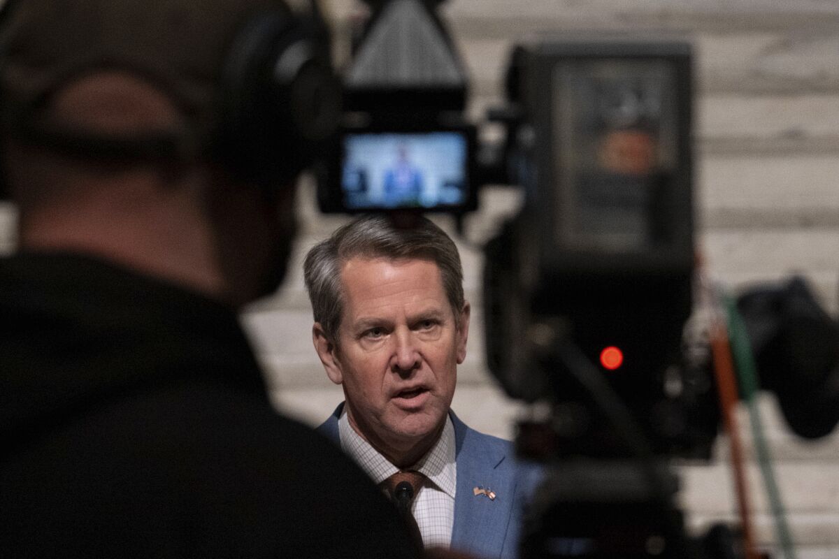Georgia Gov. Brian Kemp, center, holds a press conference Wednesday evening, Jan. 6, 2021, at the Georgia State Capitol in Atlanta, to condemn the breach of the U.S. Capitol. (AP Photo/Ben Gray)