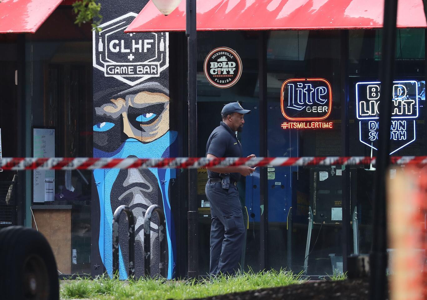 A Jacksonville Sheriff officer walks past the GLHF Game Bar where 3 people including the gunman were killed at the Jacksonville Landing on August 27, 2018 in Jacksonville, Florida.