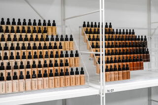 Bottles of different shades of foundation on a shelf in a room that showcases products that the company has manufactured for brands and also newer products developed by researchers at the COSMAX building in Seongnam, Gyeonggi Province, South Korea, on Wednesday, August 20, 2025.