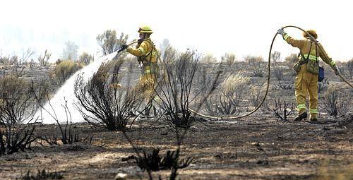 Firefighters hose down hot spots along Lockwood Valley Road. The area was evacuated today as the Day Fire, which has burned for more than three weeks, grows into the sixth largest wildfire in California history.