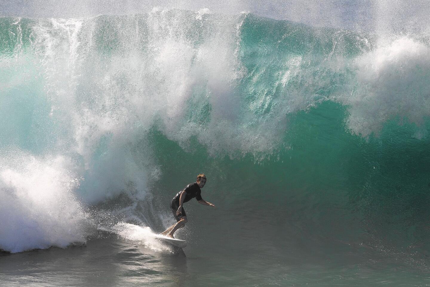 A surfer catches a wave at the Wedge on Tuesday morning in Newport Beach.