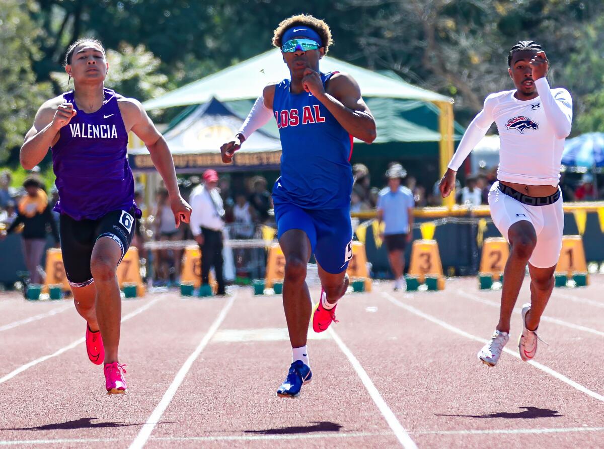 Devin Bragg of Los Alamitos wins the Division 1 100 in 10.38 seconds, beating Valencia's Brian Bonner (left) 