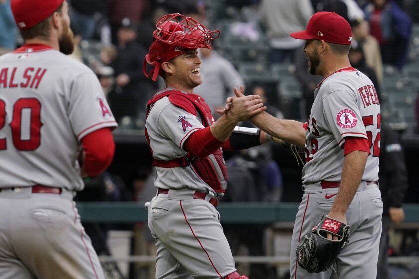 Angels catcher Max Stassi, center, celebrates with relief pitcher Ryan Tepera after the win.