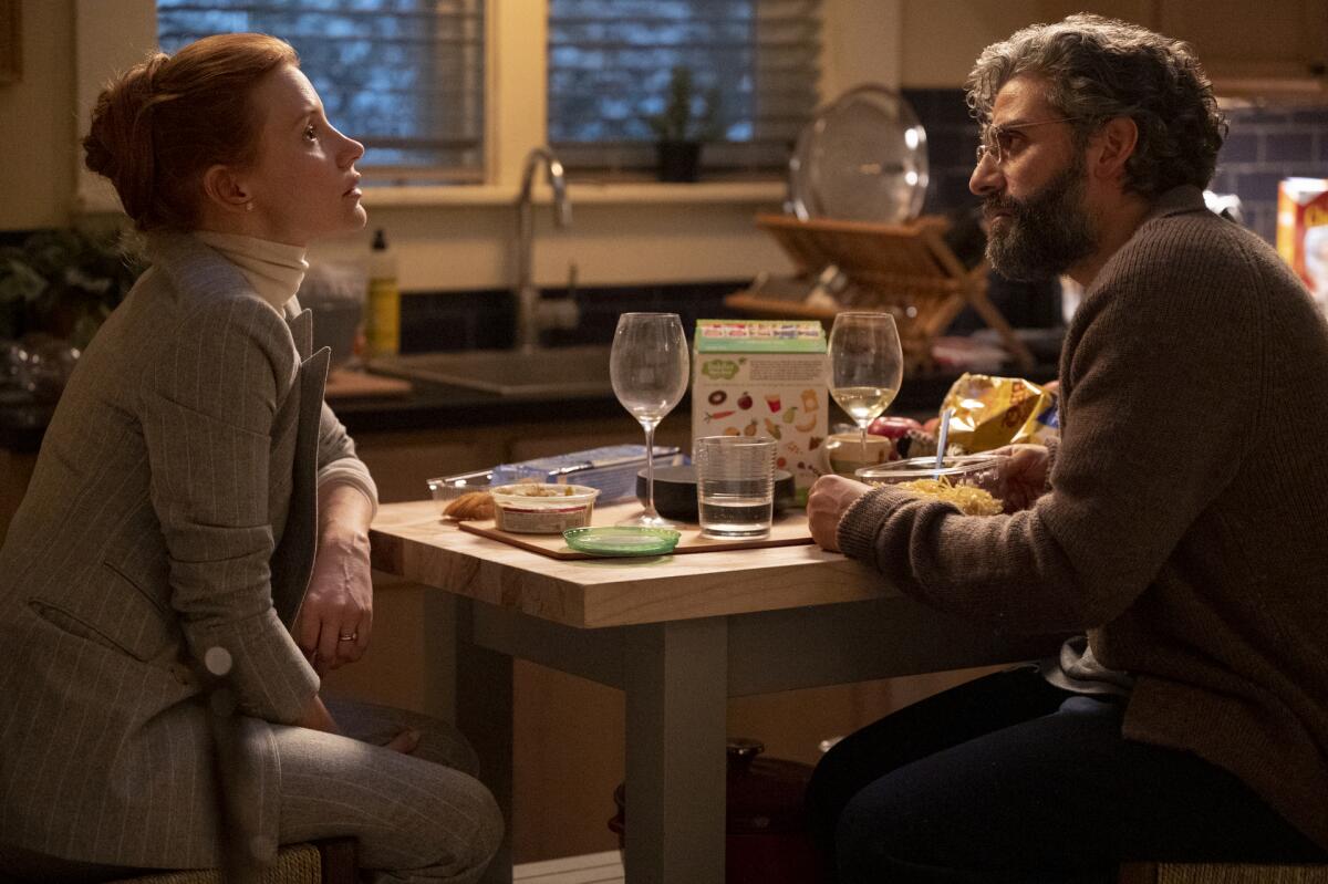 A man and a woman sit it a table during a meal.