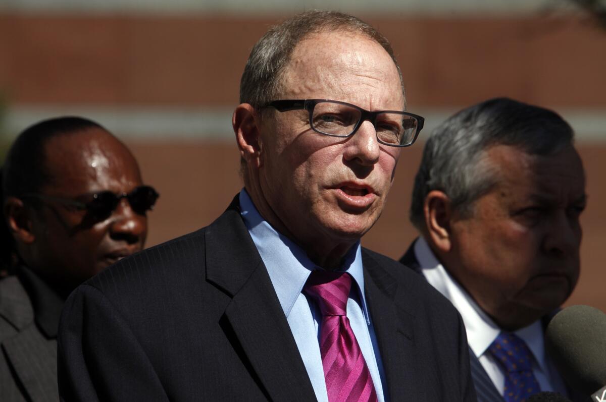 Attorney Steven Lerman, center, announces the filing of a federal lawsuit seeking punitive and compensatory damages and a claim against Los Angeles for $75 million on behalf of the family of Ezell Ford, who was shot and killed by LAPD officers.