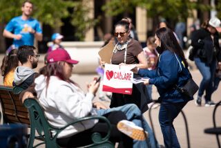 Valerie Traina and Trisha Tahmasbi, both volunteers of California Nurses Association, speak to people about CalCare, proposed legislation for a single-payer health care coverage system, at Balboa Park on Saturday, March 25, 2023.