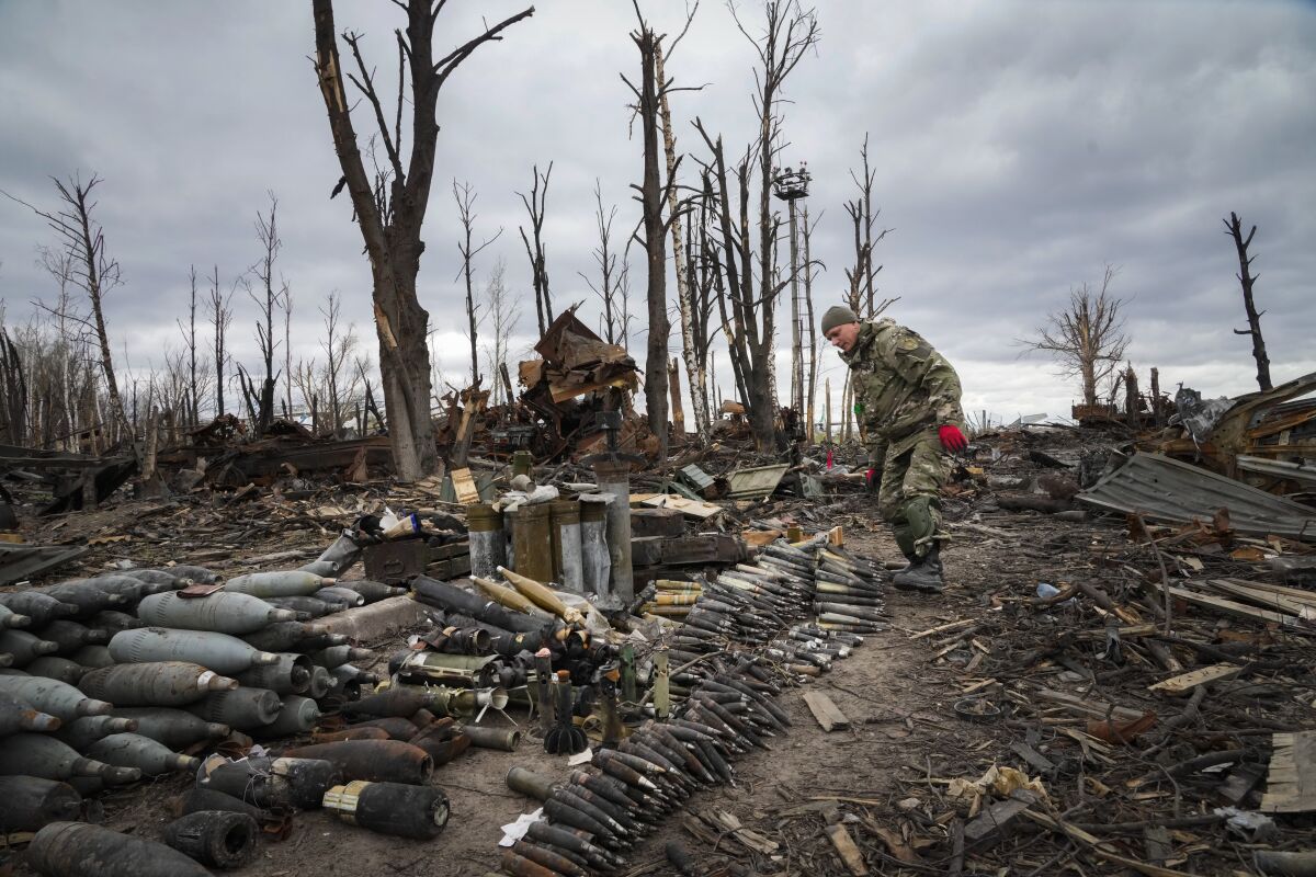 An interior ministry sapper collects unexploded shells, grenades and other devices in Hostomel, close to Kyiv, Ukraine, Monday, April 18, 2022. (AP Photo/Efrem Lukatsky)