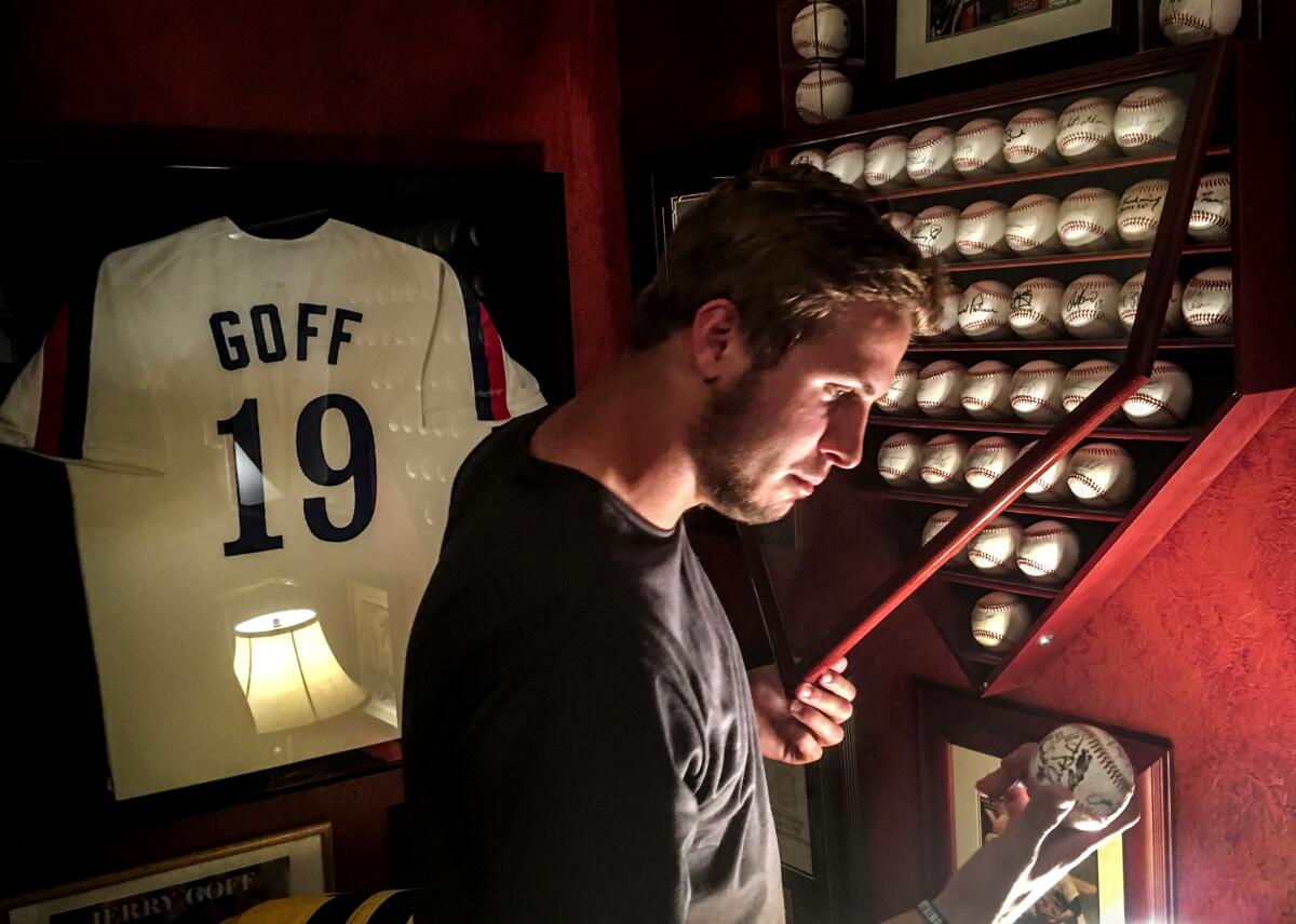 Jared Goff examines one of his father's commemorative baseballs in the family's home in Novato, California.