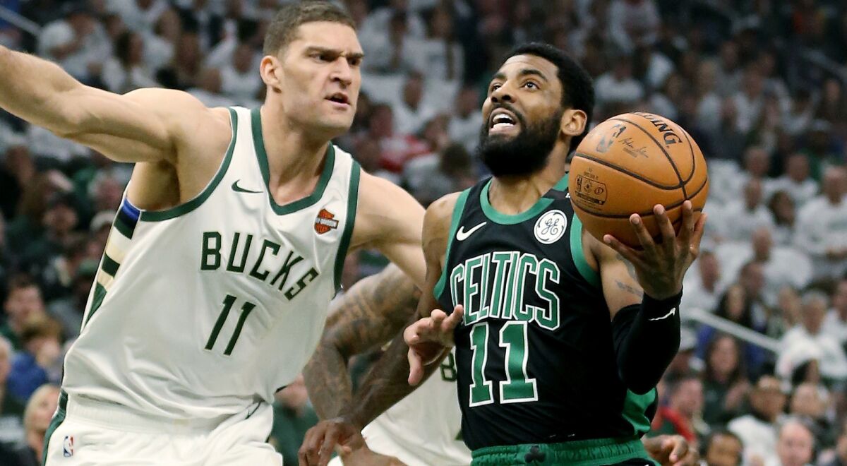 Celtics guard Kyrie Irving drives down the lane for a layup against Bucks center Brook Lopez during the first half of Game 1 on Sunday.