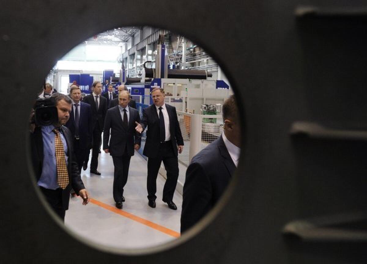 Russian President Vladimir Putin, center, visits a machinery factory in St. Petersburg. Putin was not enthusiastic in remarks responding to President Obama's call for further reductions in nuclear weapons by the U.S. and Russia.