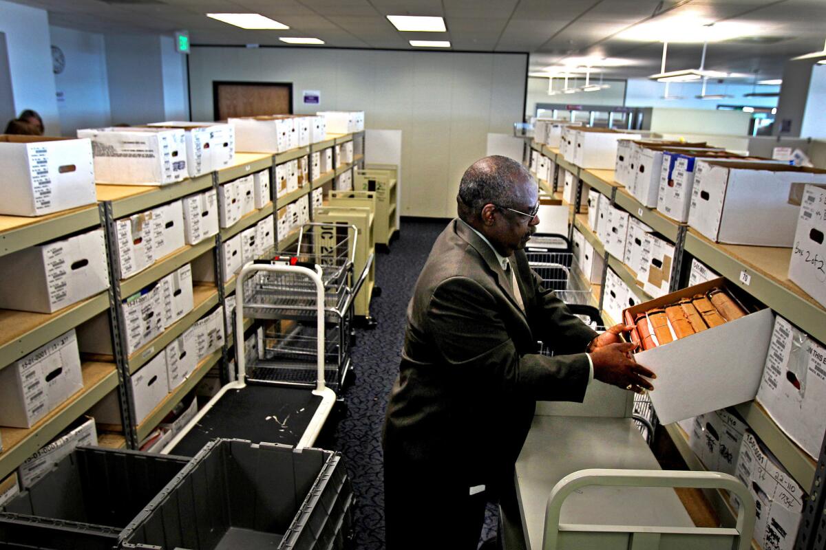 Douglas Bragg, the director of the Veterans Benefits Administration office in Oakland, looks into one of the many boxes that contain the cases of veterans with pending claims.