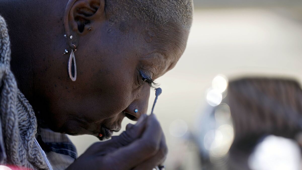 Alice Simpson, 57, of Alabama, does her makeup as she waits to board a bus.