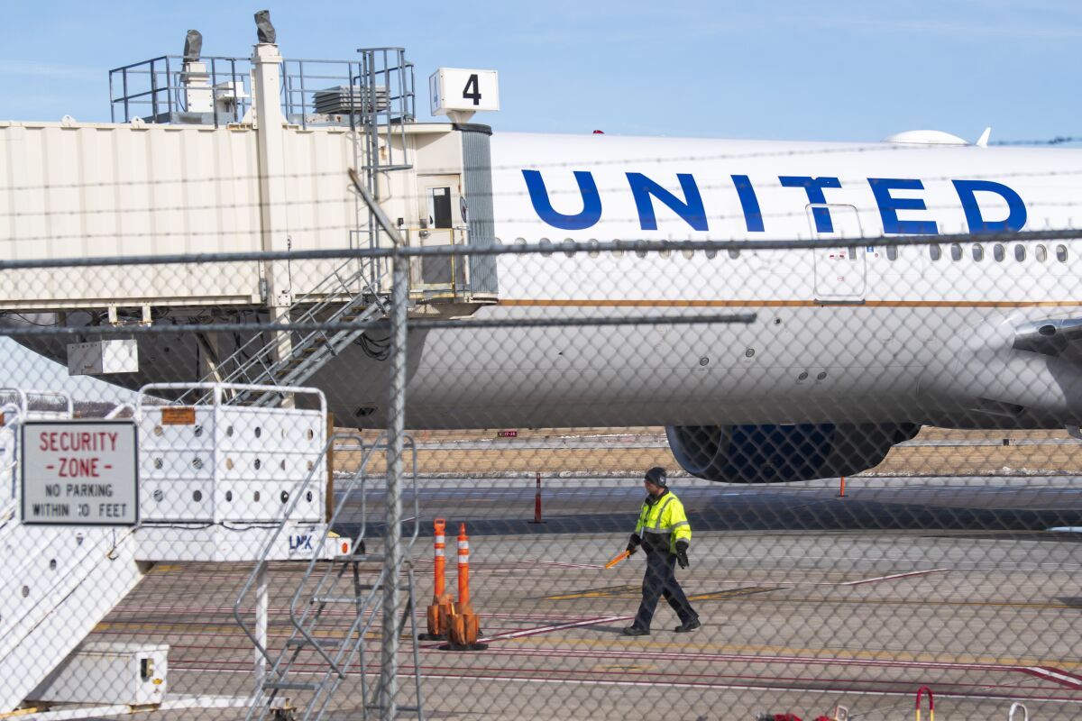 Members of the ground crew secure the site after a United airlines flight made an emergency landing at the Lincoln airport on Saturday, Feb. 4, 2023. The flight headed from Chicago to Las Vegas made an unplanned stop in Nebraska on Saturday after the pilot reported engine problems.(Kenneth Ferriera/Lincoln Journal Star via AP)