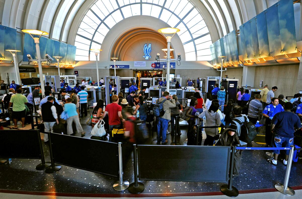 In a file photo, passengers wait to pass through security at LAX.