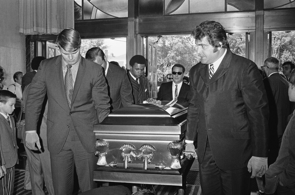 Chicago Bears teammates of Brian Piccolo, including Gale Sayers, back, carry his coffin at his funeral in  June 1970.
