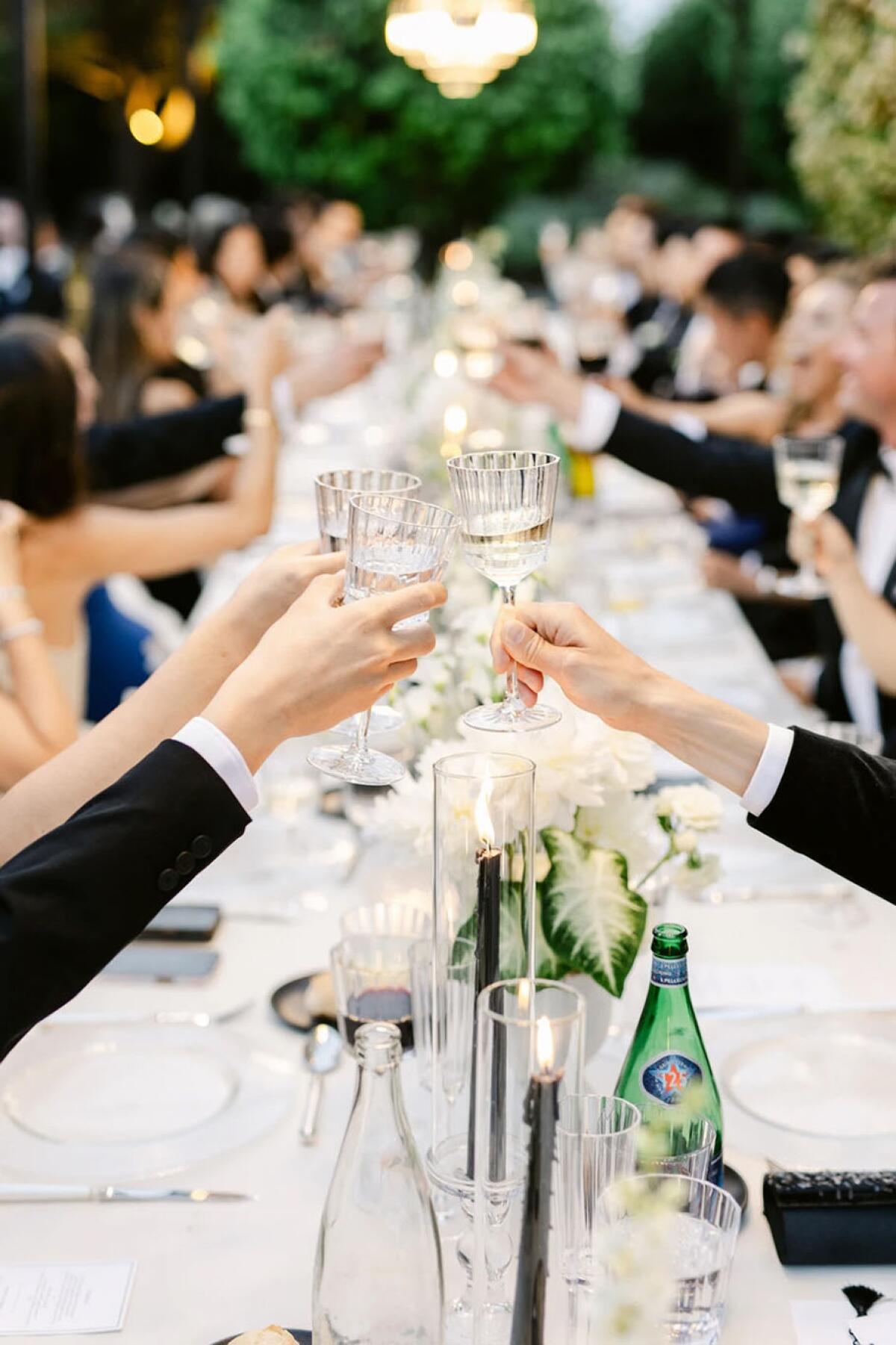 Guests toast at an outdoor wedding reception at the Bastide du Roy.