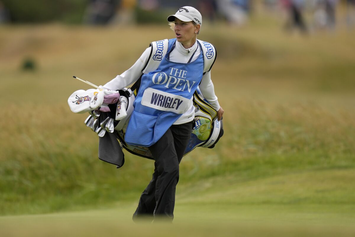Johanna Gustavsson carries her husband Alex Wrigley's clubs at the British Open.