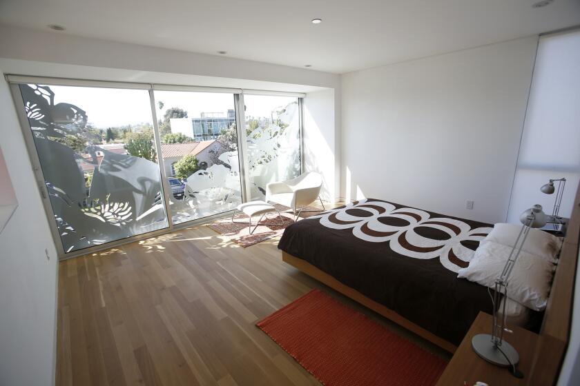 At the end of the second floor, the poppy motif visible from the street creates patterns of light in the master bedroom. At left, out of screen, as pass-through looks down onto the living room below.