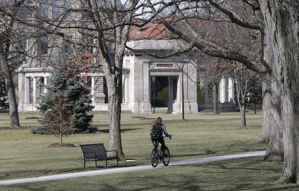 FILE-This March 5, 2013 file photo shows a student riding a bicycle on the campus of Oberlin College in Oberlin, Ohio. The 9th District Court of Appeals upheld a $31 million judgment on Thursday, March 31, 2022 against Oberlin College that had been awarded to Gibson's Bakery and Food Mart that successfully claimed it was libeled by the school after a shoplifting incident in November of 2016. The court rejected all of the college's appeal arguments. Oberlin students and staff staged protests outside the market after the shoplifting incident . A jury in June 2019 awarded story owners $44 million in compensatory and punitive damages and $6 million in attorney fees. The Gibsons' award was later reduced by a judge to $25 million. (AP Photo/Tony Dejak, File)