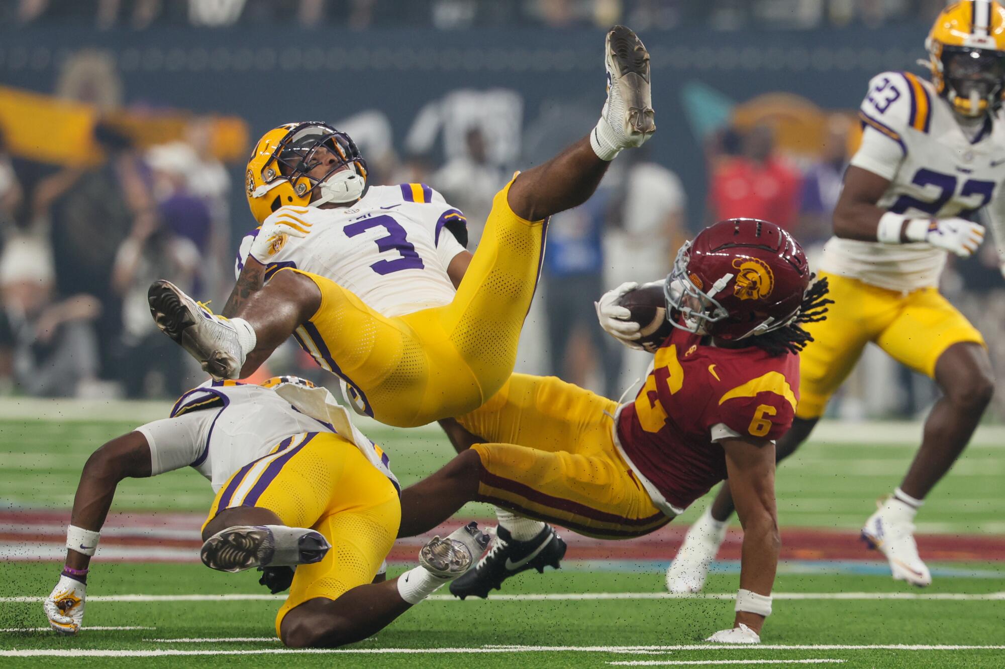 USC Trojans wide receiver Makai Lemon is tackled by LSU Tigers safety Sage Ryan.