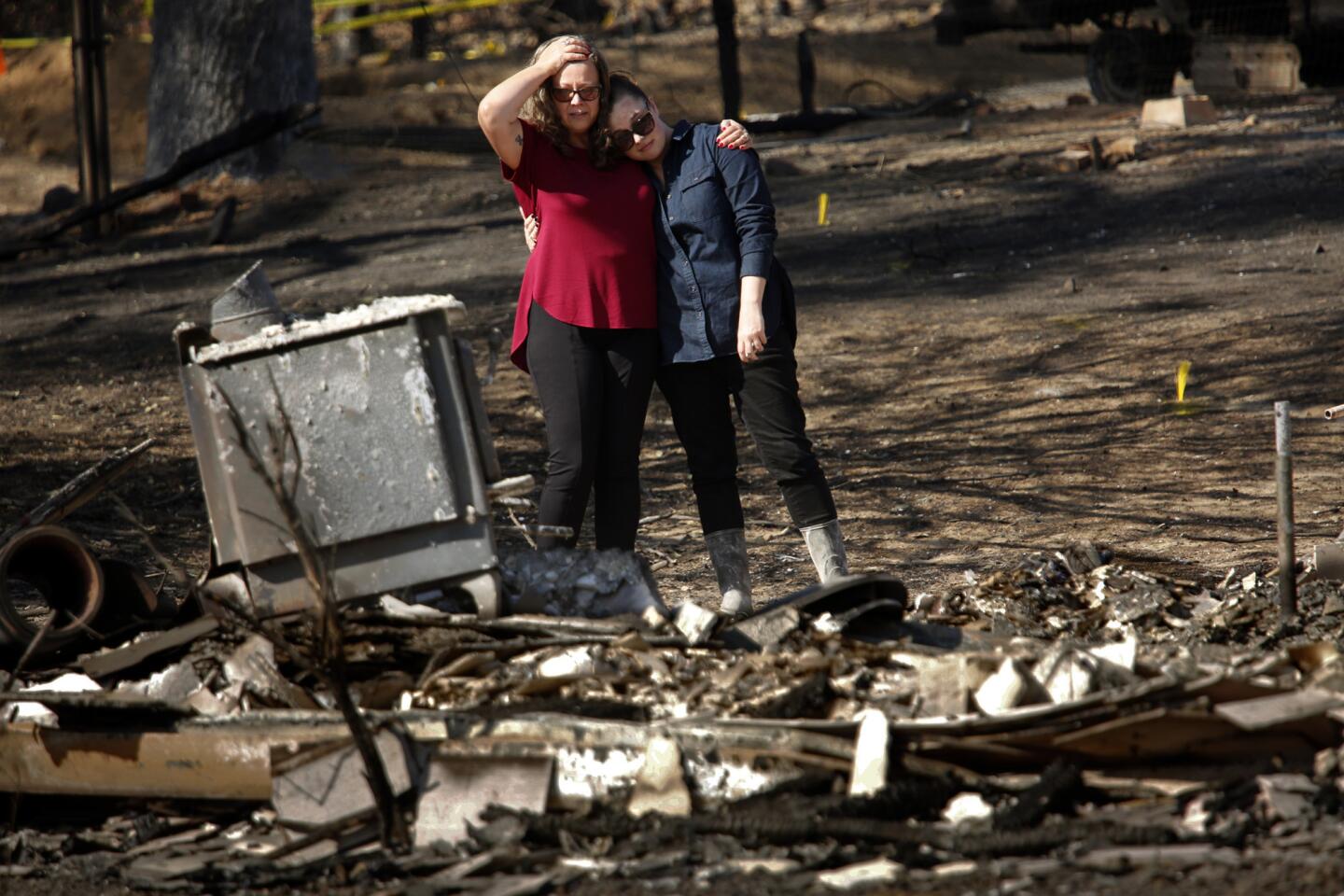 Dee Pallesen, left, and daughter Emily Learn console each other as they look over the remains of Pallesen's home on Fisher Lake Drive, which was destroyed by the Redwood Valley fire.