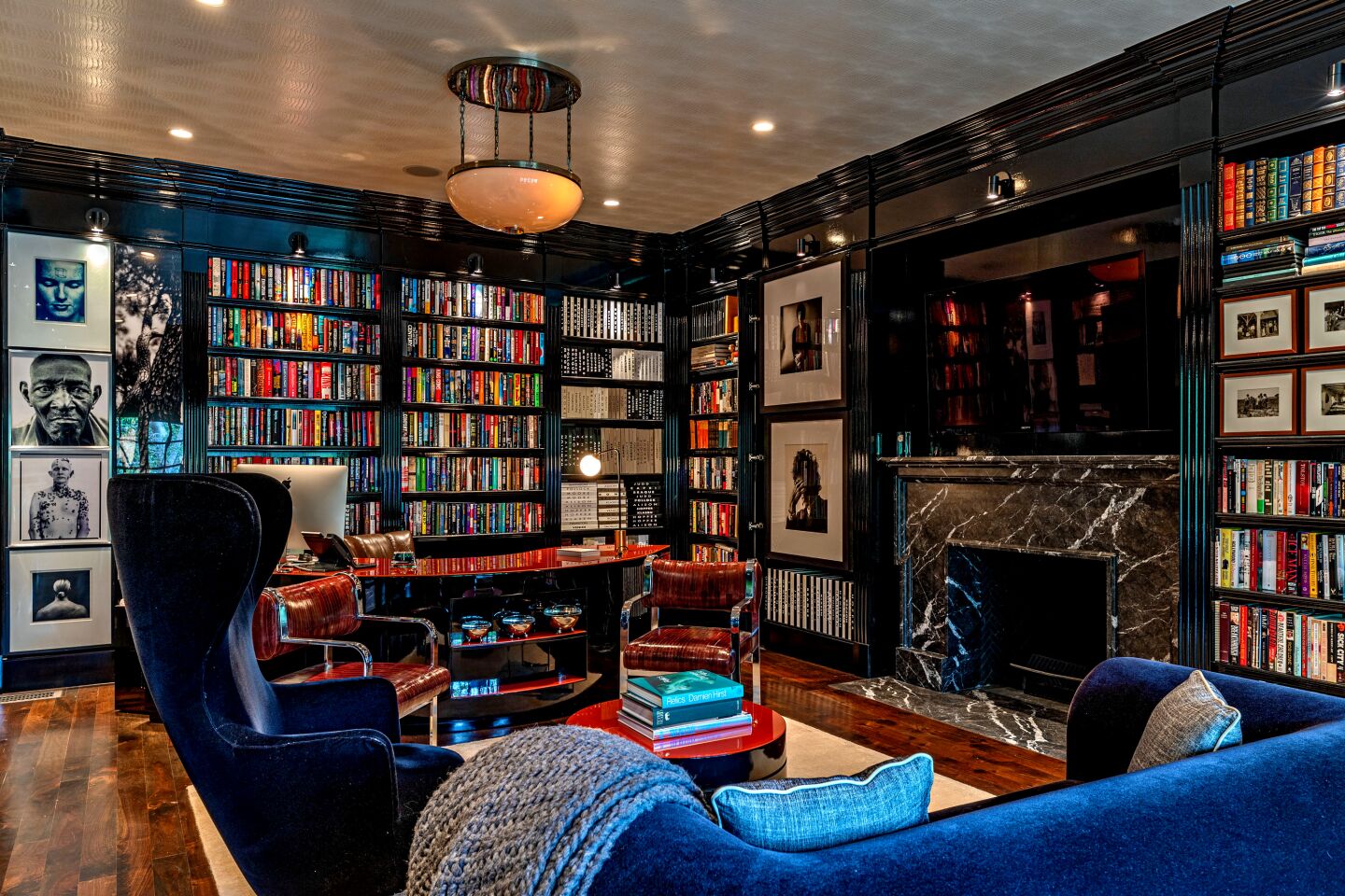 A furnished room with built-in book shelves filled with books and pictures on the wall.