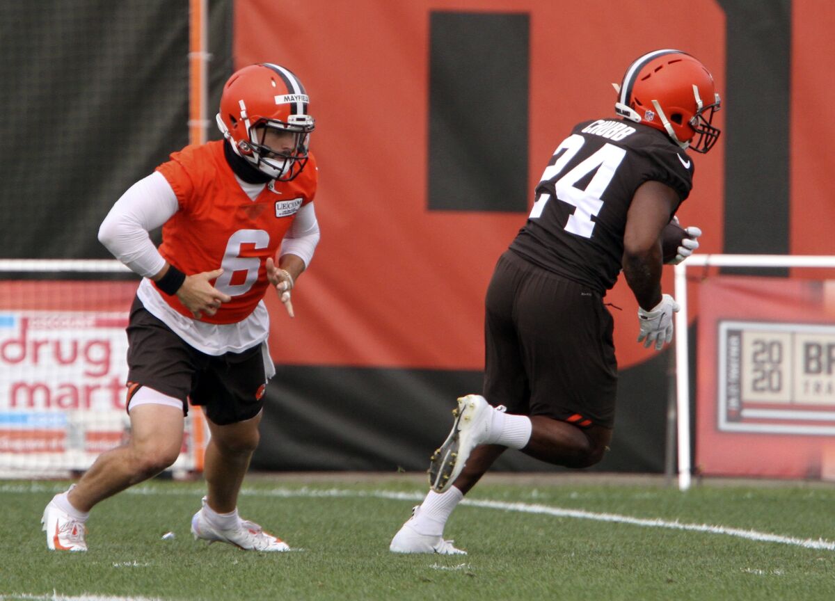 Cleveland Browns' Baker Mayfield (6) hands off the ball to Nick Chubb (24) during drills at NFL football practice Sunday, Aug. 16, 2020, in Berea, Ohio. (David Petkiewicz/The Plain Dealer via AP)
