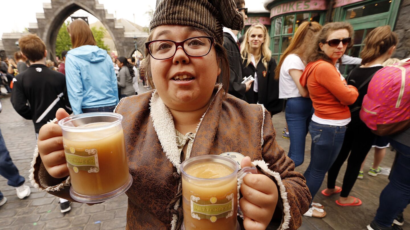 Jessica Morga serves butterbeer to some of the thousands visiting the attraction on opening day.
