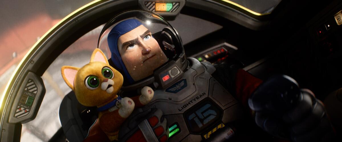 An animated astronaut and cat huddle together in a scene from Disney and Pixar’s “Lightyear.” 
