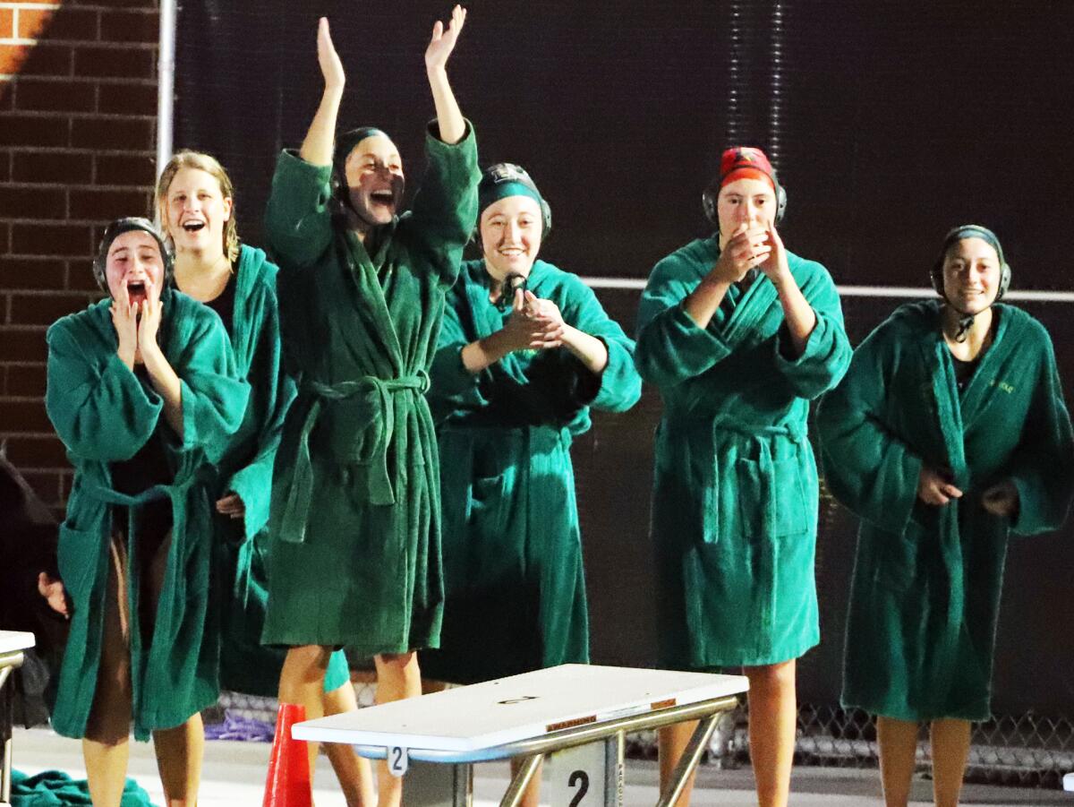Members of the Edison High girls' water polo team cheer as the Chargers won against Woodbridge on Wednesday night.