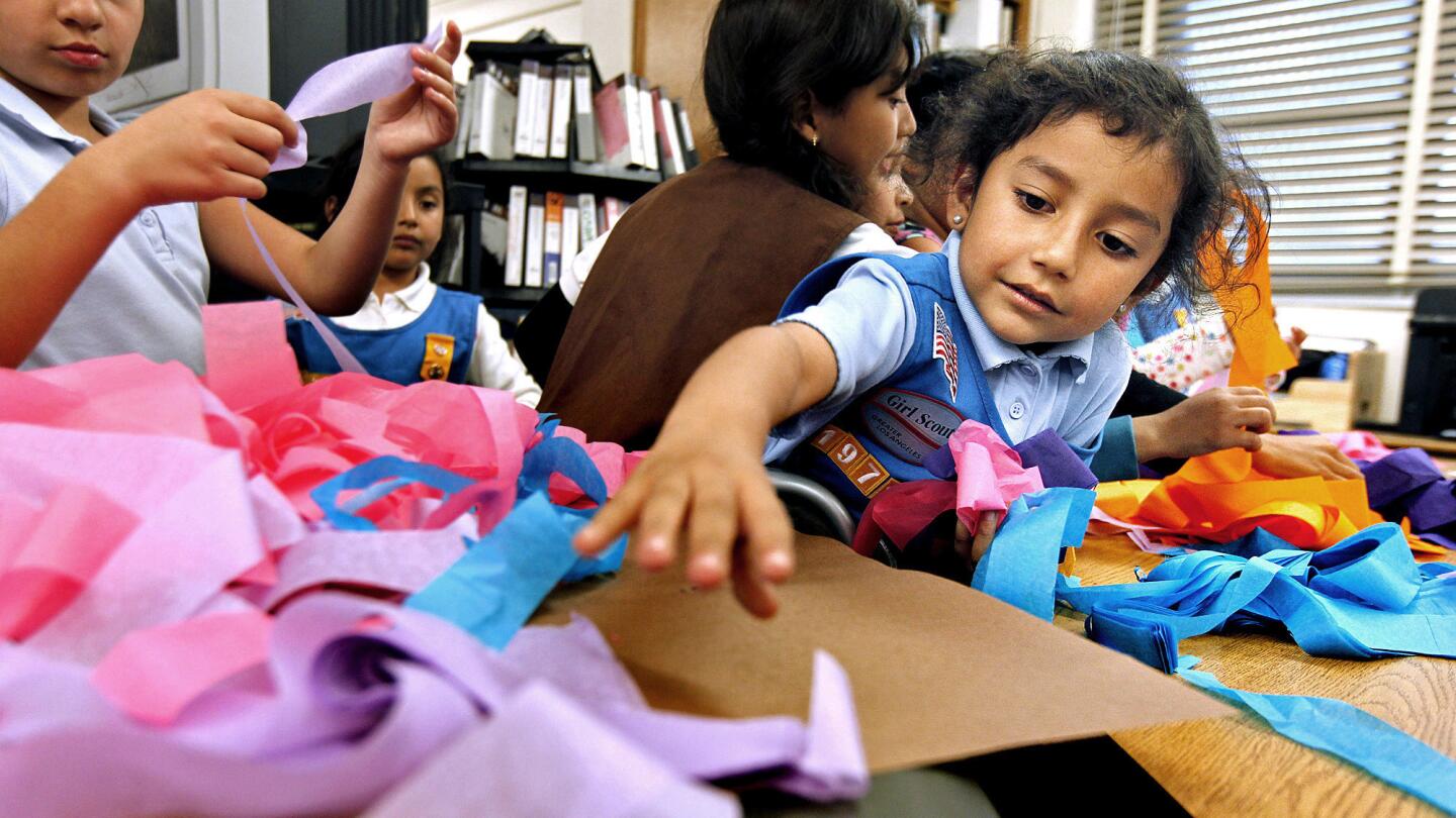 Edith Moreno, right, works on an arts and crafts project during a Girl Scout meeting at Grape Street Elementary School in Watts.