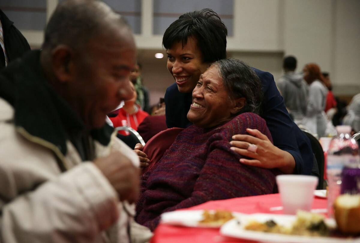 Washington Mayor Muriel Bowser (2nd R) greets residents during the annual Feast of Sharing event at the Walter E. Washington Convention Center on November 25.