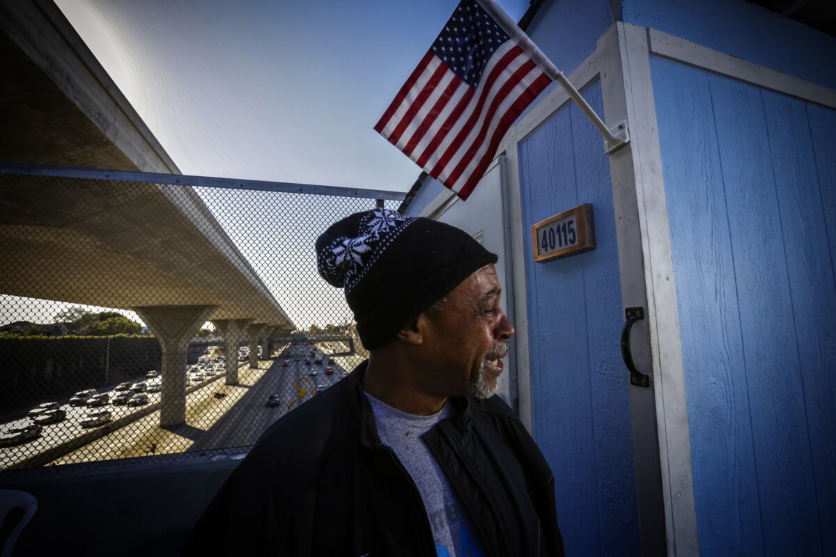 Marvin Burrus, 58, standing next his portable shelter, weeps recalling reasons for being homeless. His portable shelter is parked on 42nd Street bridge above the 110 Freeway in Los Angles.