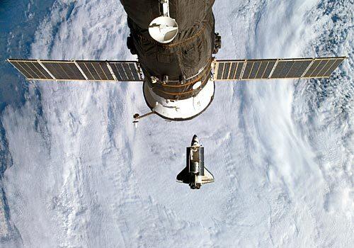 Discovery, bottom, just before linking up with the space station.