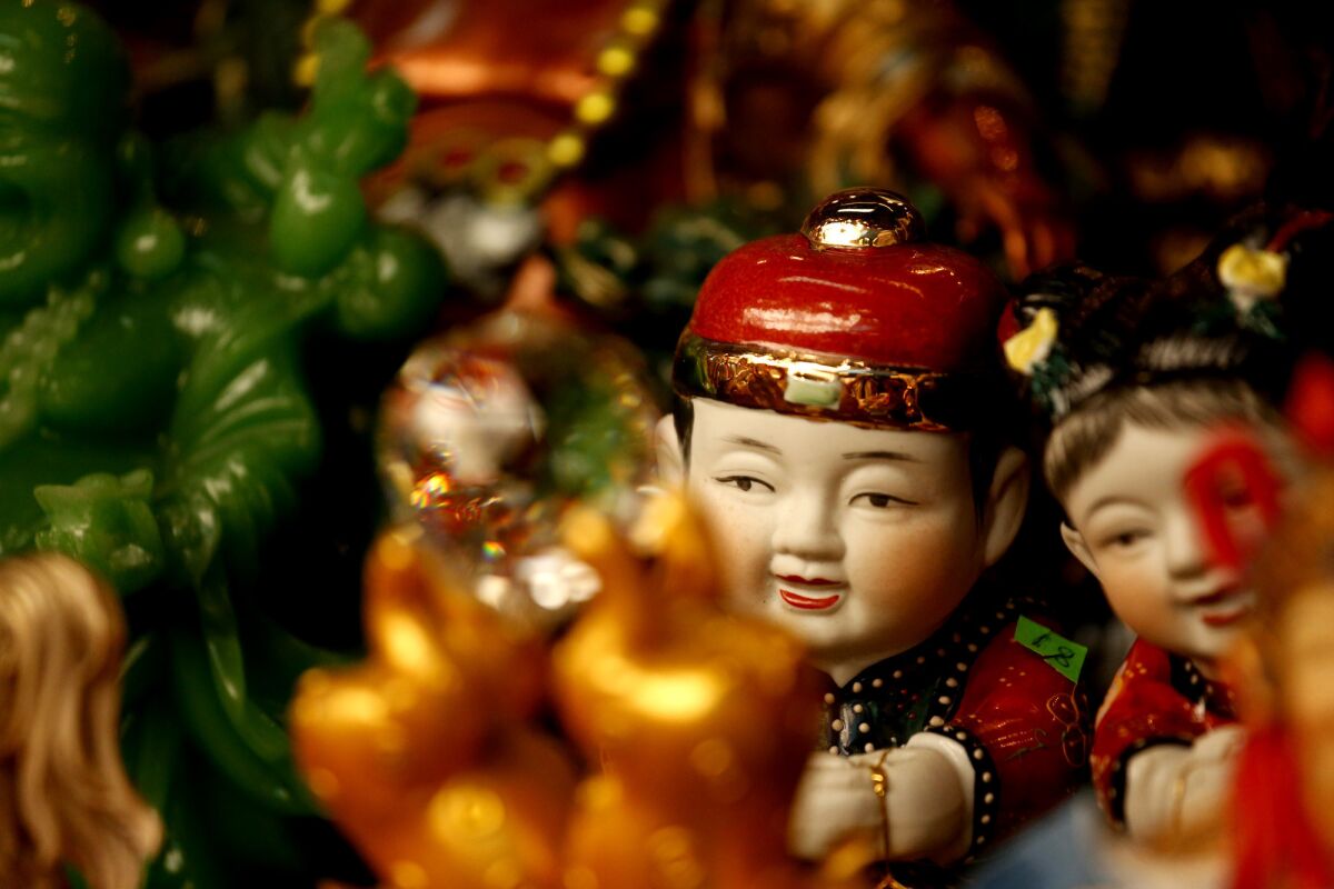 Dolls rest on a shelf in a shop at the swap meets inside Dynasty Plaza in Chinatown. (Genaro Molina / Los Angeles Times)