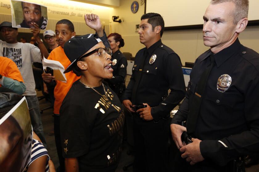 Protesters chant during an L.A. Police Commission meeting on Tuesday. The meeting, held on the first anniversary of the shooting death of South L.A. resident Ezell Ford, had to be halted briefly.