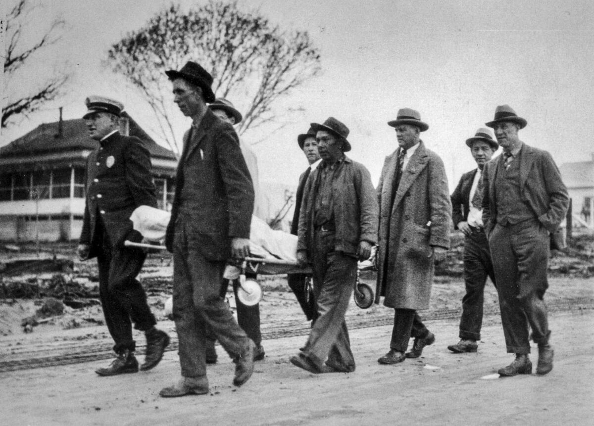 March 13, 1928: Workers carry the remains of a victim of the St. Francis Dam collapse.