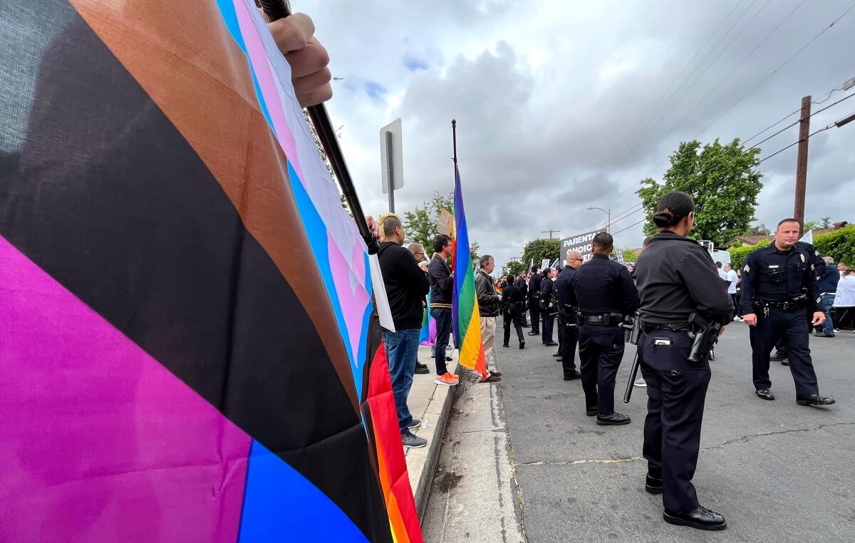 Pride flags and police officers at a protest and counterprotest outside a North Hollywood elementary school