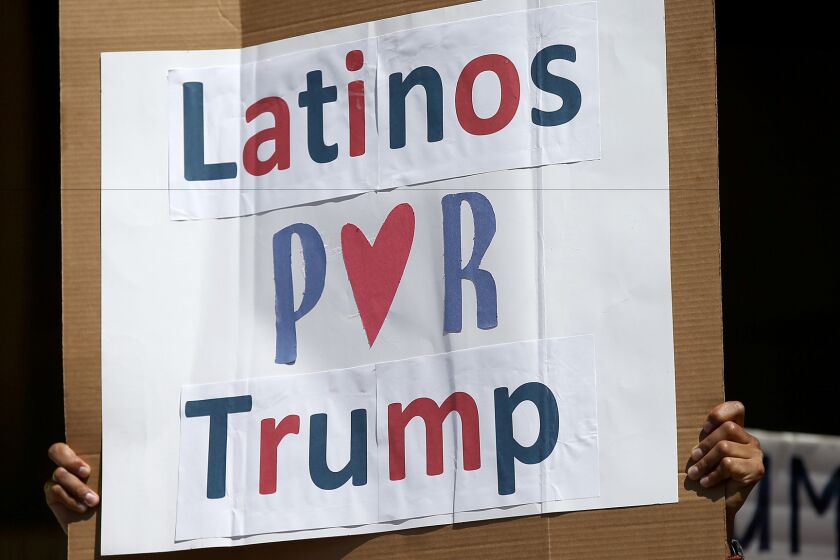 A man hoists a sign during a rally of about 100 of presidential candidate Donald Trump's Latino supporters outside Anaheim City Hall on Aug. 28.