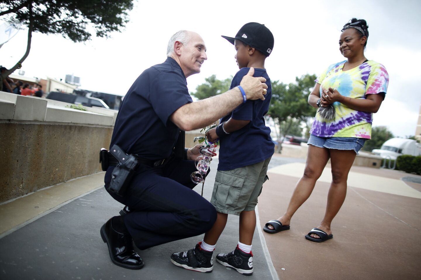 Seven-year-old Jacob Flanagan greets Assistant Police Chief, Gary Tittle, with his Mom, Jennifer Cobb, in front of the Dallas Police Headquarters.