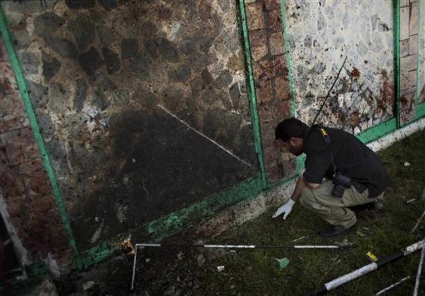 A Pakistani police officer collects evidences following an explosion in a mosque, in Chakwal city in Punjab province, about 50 miles (80 kilometers) south of Islamabad, Pakistan, Sunday, April 5, 2009. A suicide bomber attacked a crowded Shiite mosque south of the Pakistani capital on Sunday, killing 22 people and wounding dozens more, officials said. (AP Photo/Emilio Morenatti)