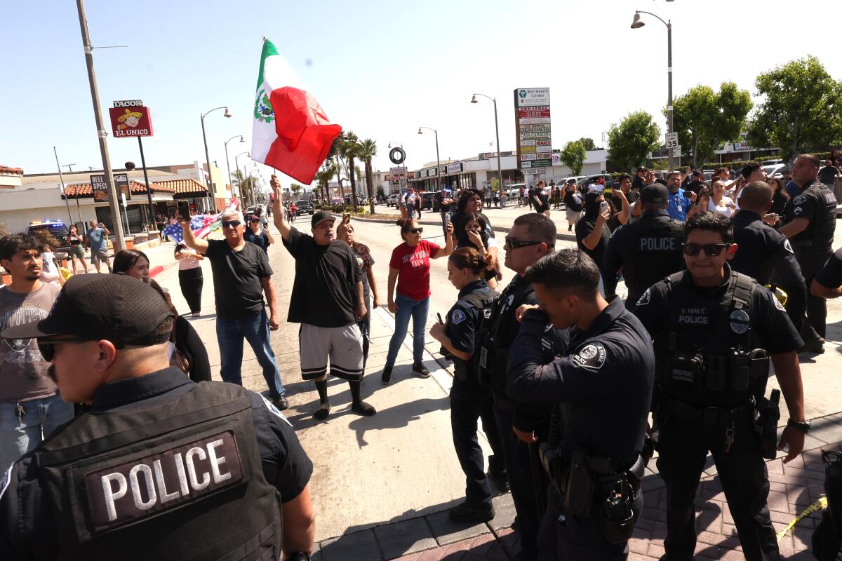 Residents stand behind a line of Vernon police officers.