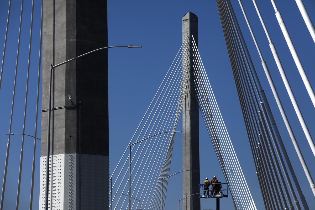 Construction workers work on the new Gerald Desmond Bridge