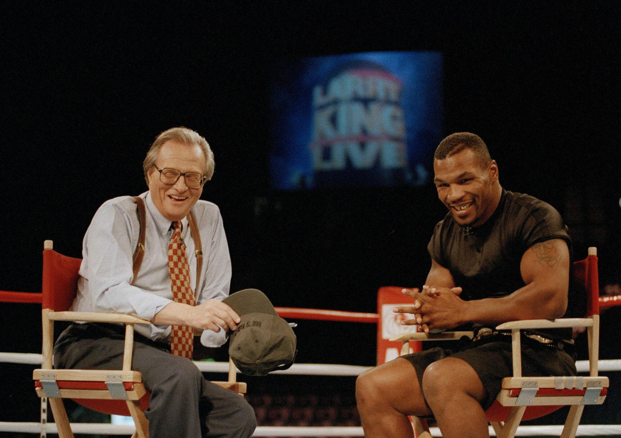 Larry King shares the ring with former heavyweight champion Mike Tyson, right, for an interview in 1999