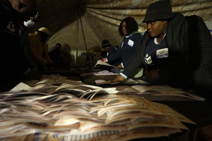 Electoral workers check ballot papers during the counting at a polling station at Itireleng informal settlement in Pretoria, South Africa, Wednesday, May 29, 2024, during the general elections. South Africans voted Wednesday at schools, community centers, and in large white tents set up in open fields in an election seen as their country’s most important since apartheid ended 30 years ago. It could put the young democracy into unknown territory. (AP Photo/Themba Hadebe)