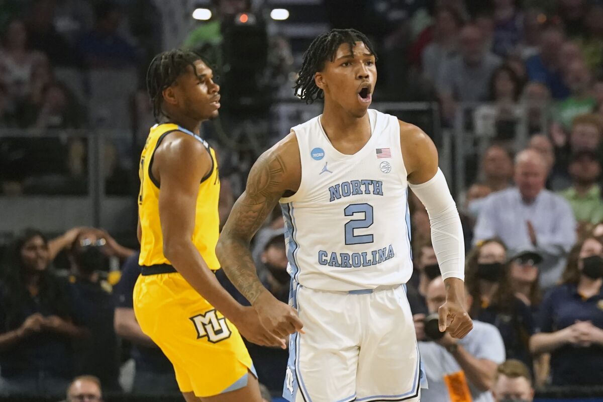North Carolina guard Caleb Love (2) reacts to scoring, in front of Marquette forward Justin Lewis during the first half of a college basketball game in the first round of the NCAA men's tournament in Fort Worth, Texas, Thursday, March 17, 2022. (AP Photo/LM Otero)