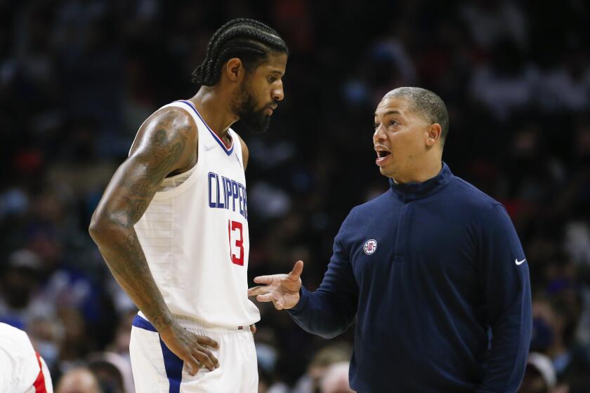 Los Angeles Clippers head coach Tyronn Lue confers with forward Paul George (13) during the second half of an NBA basketball game against the Charlotte Hornets Sunday, Nov. 7, 2021, in Los Angeles. The Clippers won 120-106. (AP Photo/Ringo H.W. Chiu)