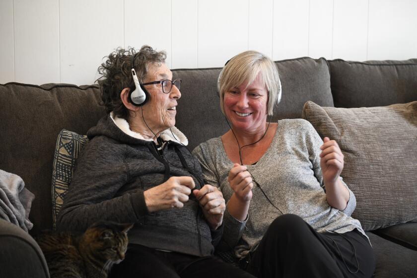Stacey Skrocki, volunteer with Jewish Family Service, right and Gloria Wasserman move to the music as they do in home music and memory therapy Monday, Dec. 9, 2019 in San Diego, California. (Photo by Denis Poroy/Union-Tribune)